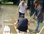 De dames draaien hun hand niet om voor de montage van een picknickbank.